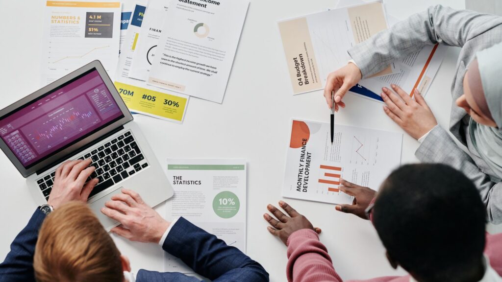 Dirigeants analysant le budget d'un contrat d'infogérance informatique autour d'un ordinateur portable