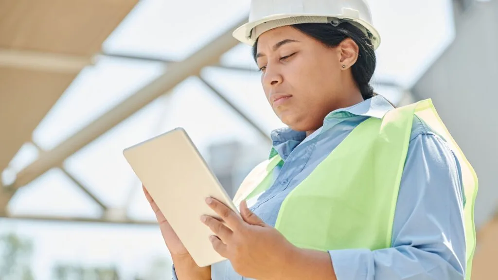 Conductrice de travaux consultant son logiciel de gestion de chantier sur tablette