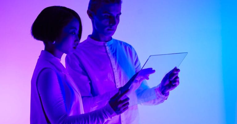 Deux professionnels consultent une facture électronique sur une tablette transparente, facture électronique 2026 pour les PME